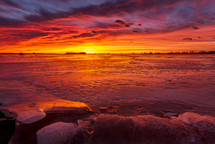 vibrant red sky over a frozen lake 