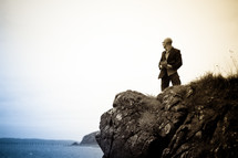 a man standing near the edge of a sea cliff 