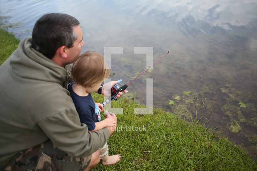 father and son fishing at a pond