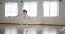 Little girl dancing alone in a studio