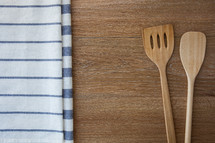 wooden spoons and towels on wood 