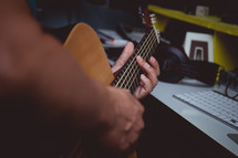 man playing an acoustic guitar in a studio