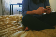 a teen girl texting on her cellphone in her room 