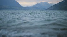 Small waves and rolling surface of a mountain lake in slow motion