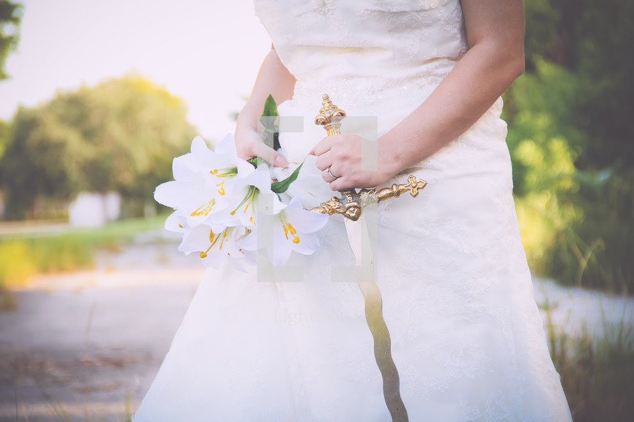 a bride holding a flowers and a sword