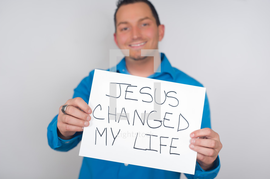 man holding a Jesus changed my life sign 