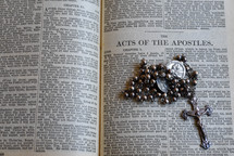 rosary on the pages of a Bible 