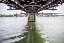 fishing in a canoe under a bridge 