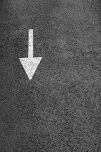 White arrow on the dark gray asphalt