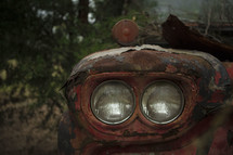 Headlights on an old, rusty vehicle.