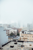 City  buildings covered in fog.