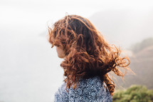 a woman's red hair blowing in the wind 