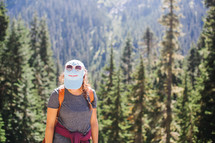 a woman hiking outdoors looking down at the ground 