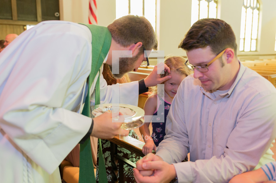 child receiving a blessing during communion 