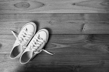 white sneakers on a wooden floor 
