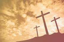 three crosses on a mount at sunrise 