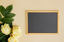 yellow roses and blank chalkboard 