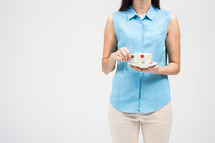 a woman holding a tea cup and saucer 