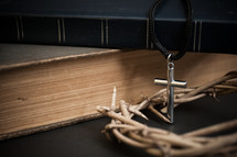 crown of thorns and cross necklace on a stack of books 