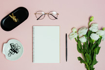 notebook, reading glasses, and white roses 