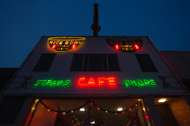 Small town restaurant with neon signs and Christmas lights at night
