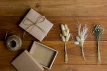 wrapped brown paper gift box and wheat and flower stalks 