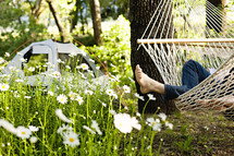 A person reclining on a hammock near a tent feet relaxation camping peace