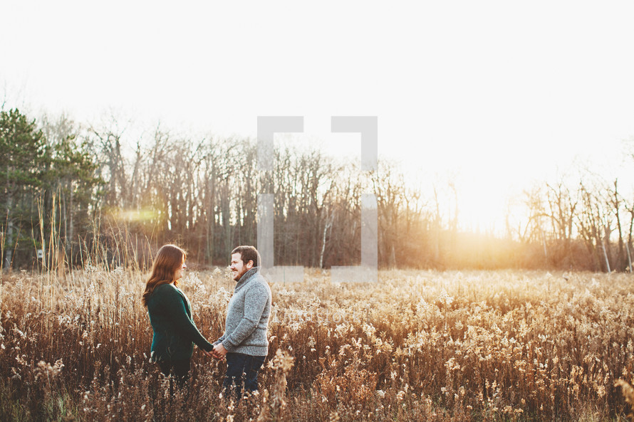 a couple standing in a golden field 