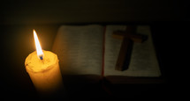 Candle with the Bible on wooden table in the night. worship prayer and bible study concept.