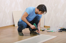 Man assembling furniture on the floor.