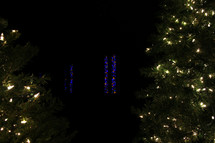 Christmas lights on Christmas trees and stained glass window 