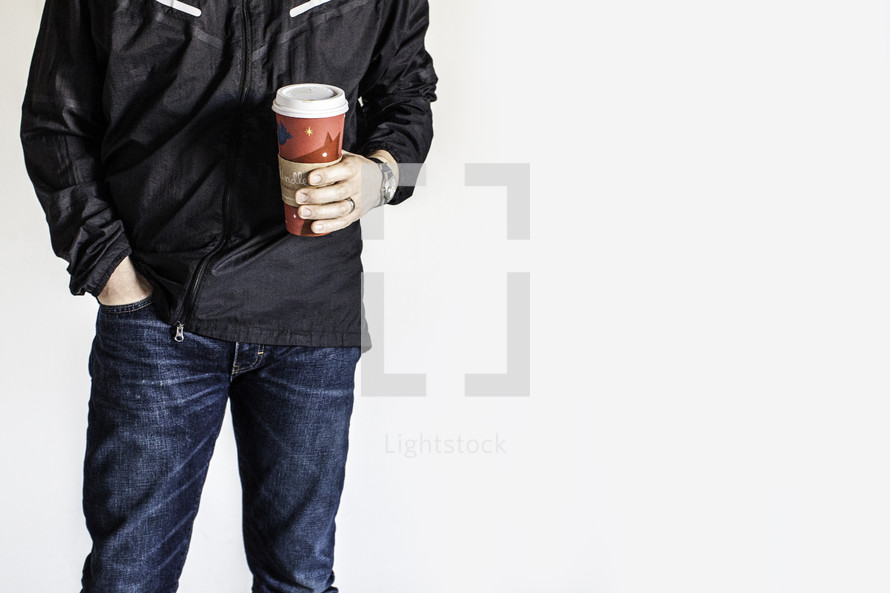 torso of man holding a coffee travel mug