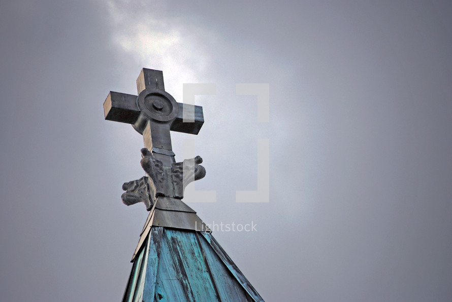 A break in the storm clouds highlights the decorative cross atop the steeple of St. Michael's Basilica in Pensacola FL.
