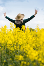 woman with outstretched arms in a field