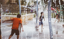 Children playing in a water fountain.