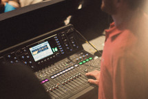 man with his hands on a soundboard 