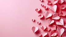 Origami paper hearts on pink background. Valentine's day concept.