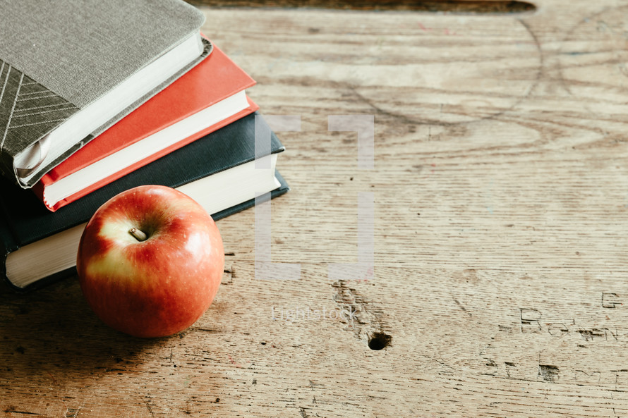 apple and books on a desk 