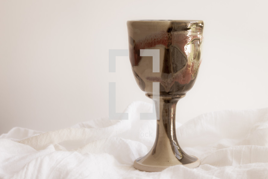 clay chalice on white linen 