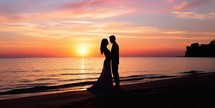 Silhouette of a bride and groom on the beach at sunset