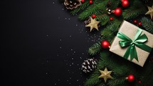 Christmas background with fir tree branches, red balls and gift box on black background