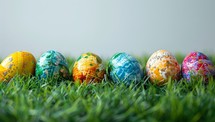 Colorful easter eggs on green grass background with copy space.