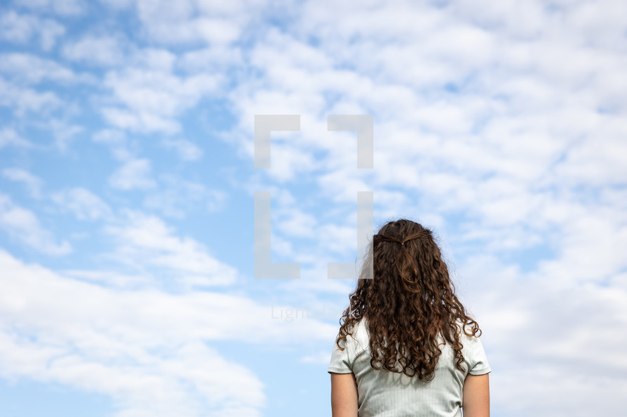 teen girl looking up at the sky 