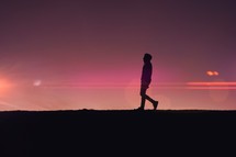 man walking in the countryside and sunset background