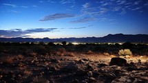 Desert landscape at night with starry sky and mountains in the background