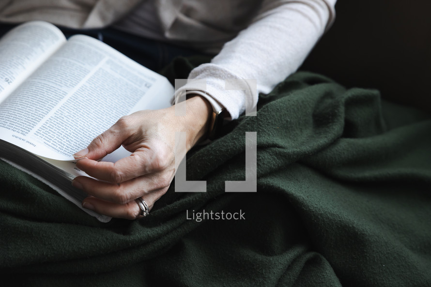 Woman with green blanket reading the Bible