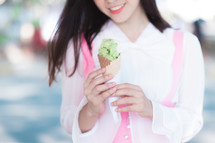 a girl holding an ice cream cone 