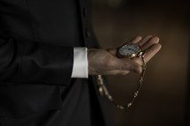 a man holding a gold pocket watch 