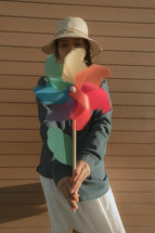 woman holding up a flower wind spinner