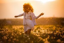 a girl dancing in a field of dandelions 